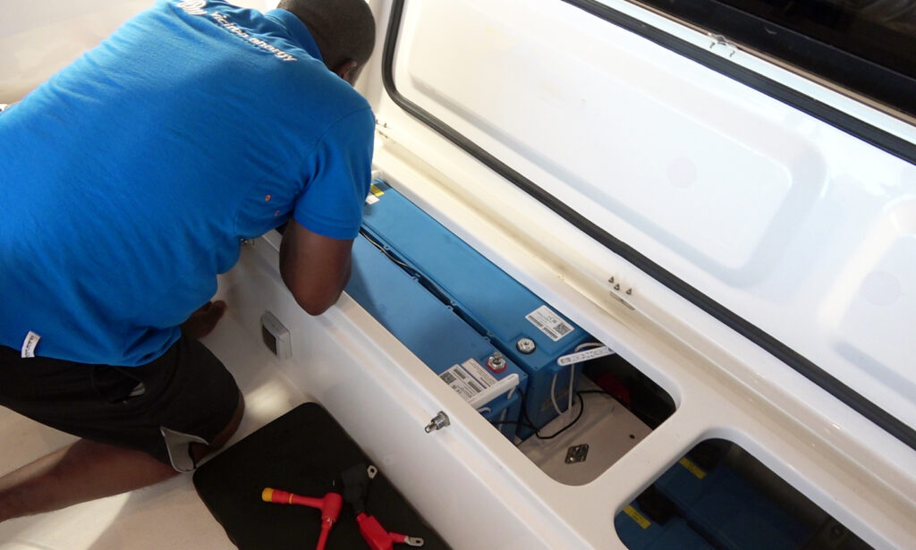 A professional installing new lithium batteries into a live aboard cruiser's boat